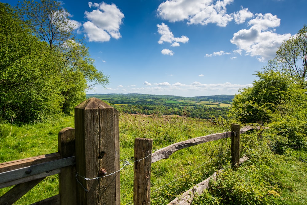 a wooden fence on a grassy hill side