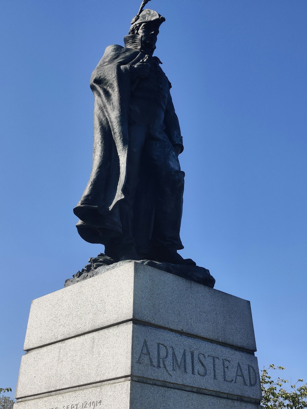 a statue of a man with a hat and cape