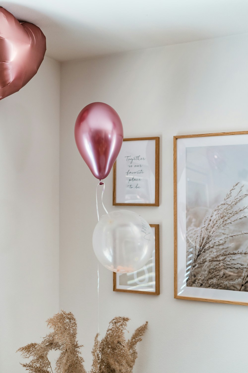 a vase filled with flowers next to two balloons