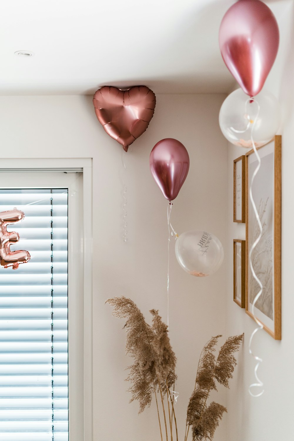 a vase filled with flowers next to balloons