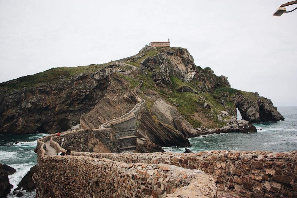 a person walking on a stone path near the ocean