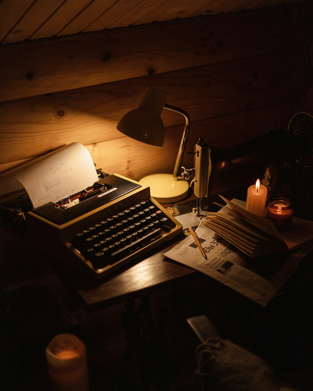 Eine altmodische Schreibmaschine sitzt auf einem Schreibtisch neben einer Lampe