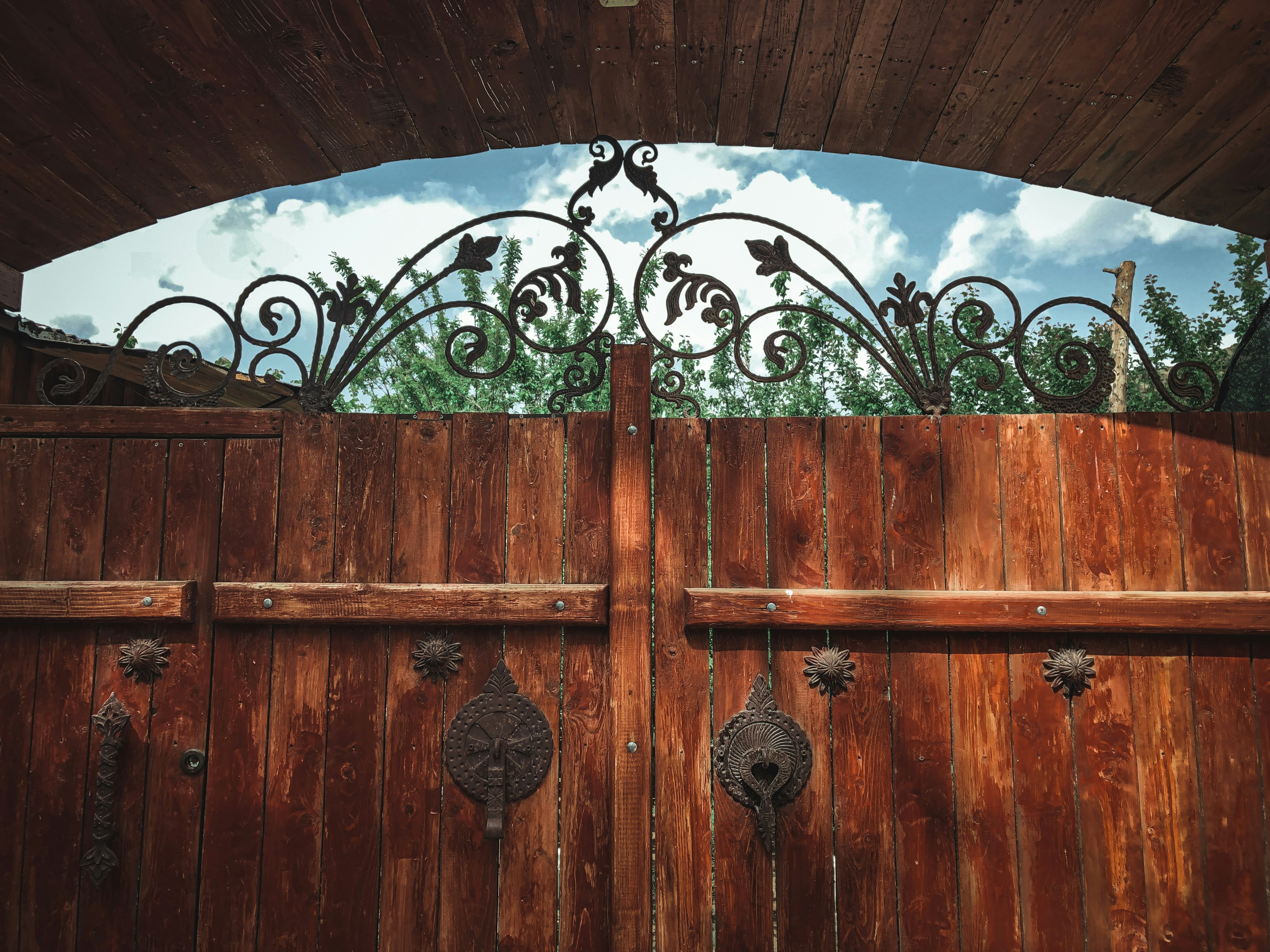 a wooden gate with iron work on it