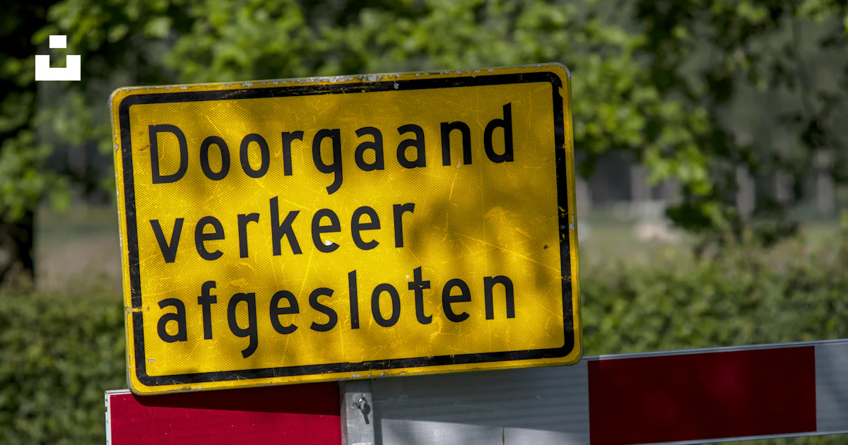 A yellow and red sign sitting on the side of a road photo – Free Road ...