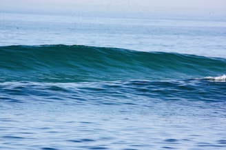a man riding a wave on top of a surfboard