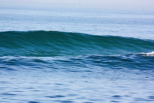 a man riding a wave on top of a surfboard
