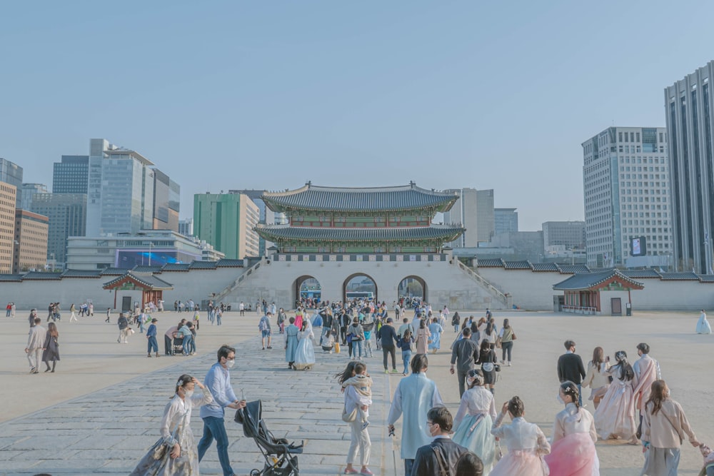 a large group of people walking around a city