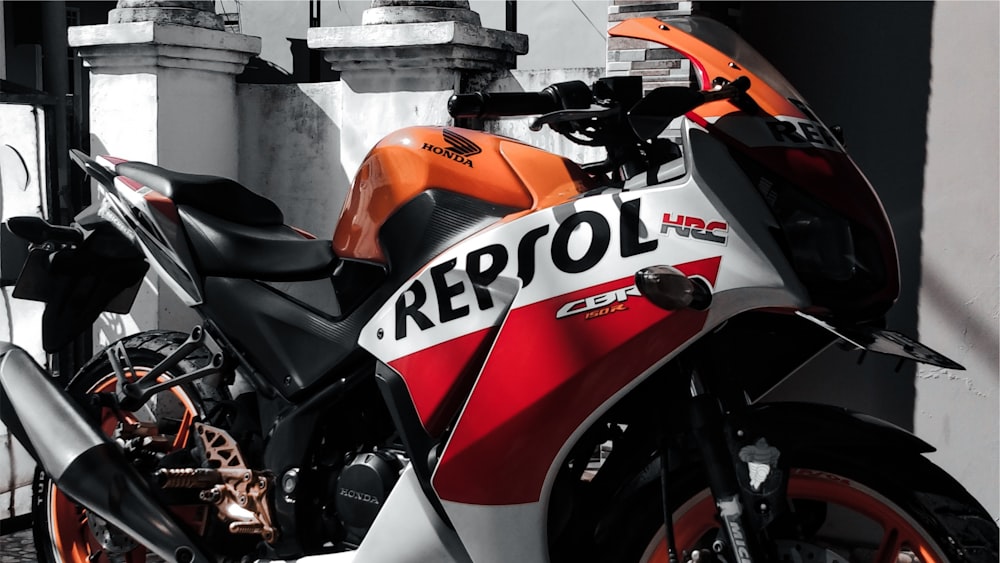 a red and white motorcycle parked in front of a building