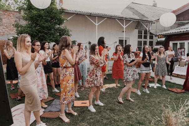 a group of women standing on top of a lush green field