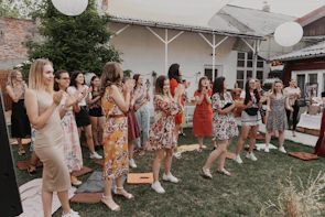 Women gathered in a circle outdoors, sharing and supporting each other in a peaceful garden setting.