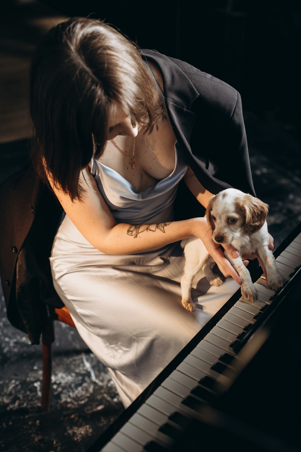 a woman playing a piano with a dog on her lap