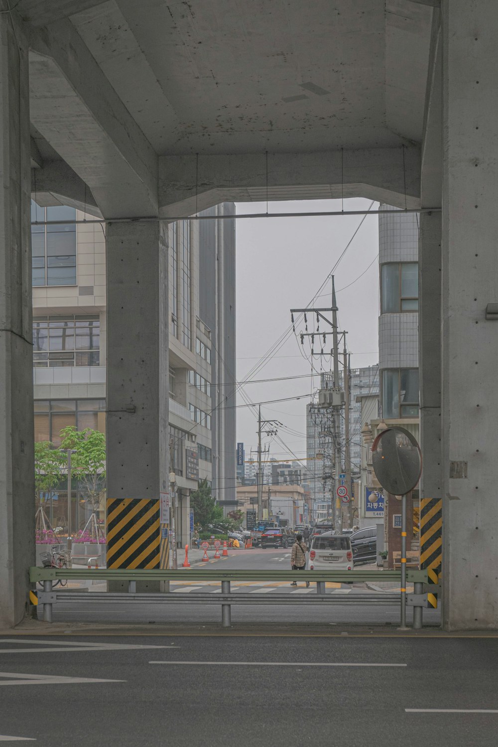a man walking down a street under a bridge