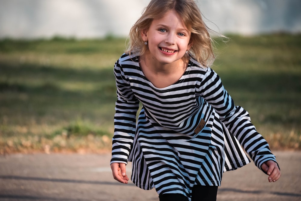 une petite fille sur une planche à roulettes dans une rue