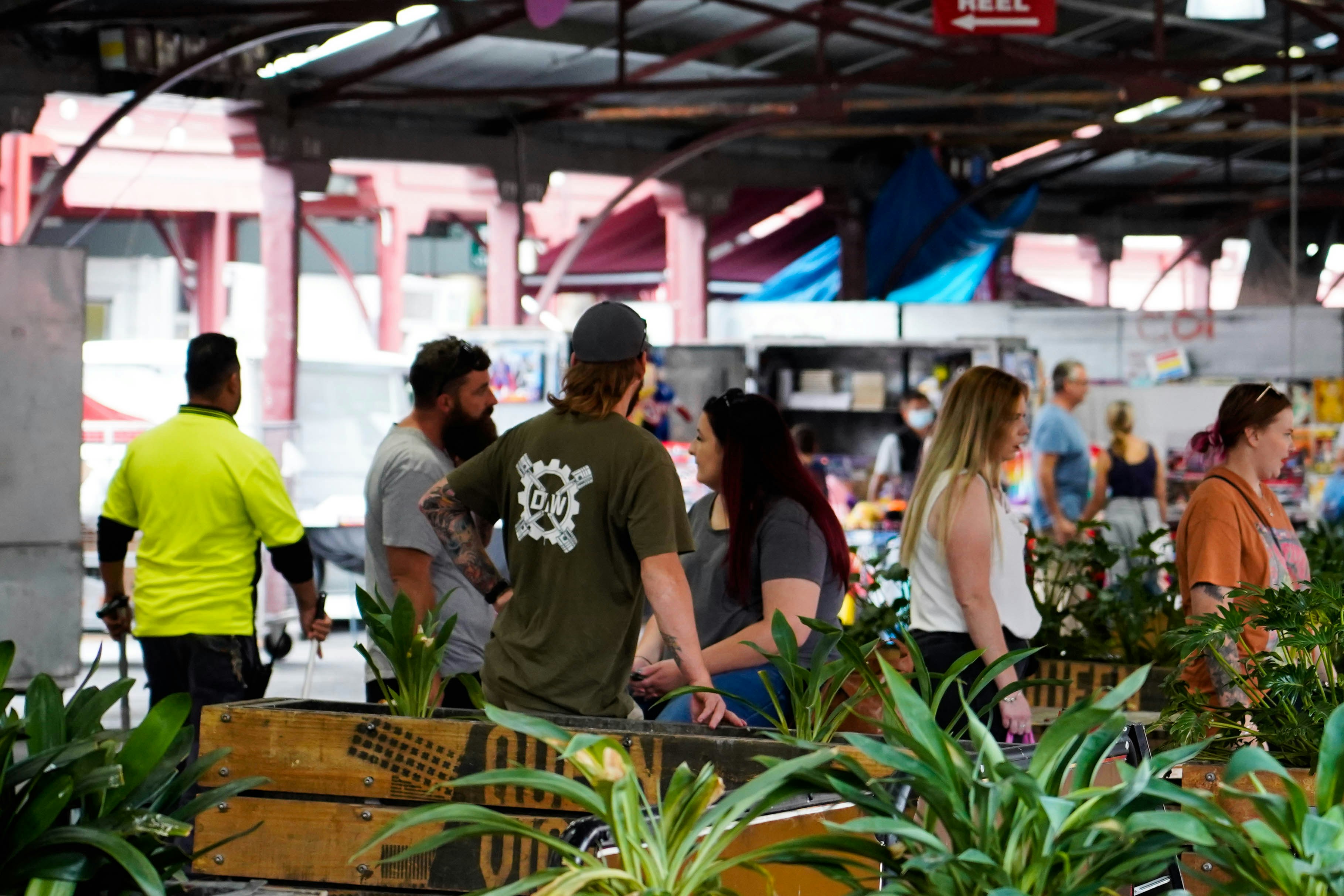 a group of people standing around a store filled with plants
