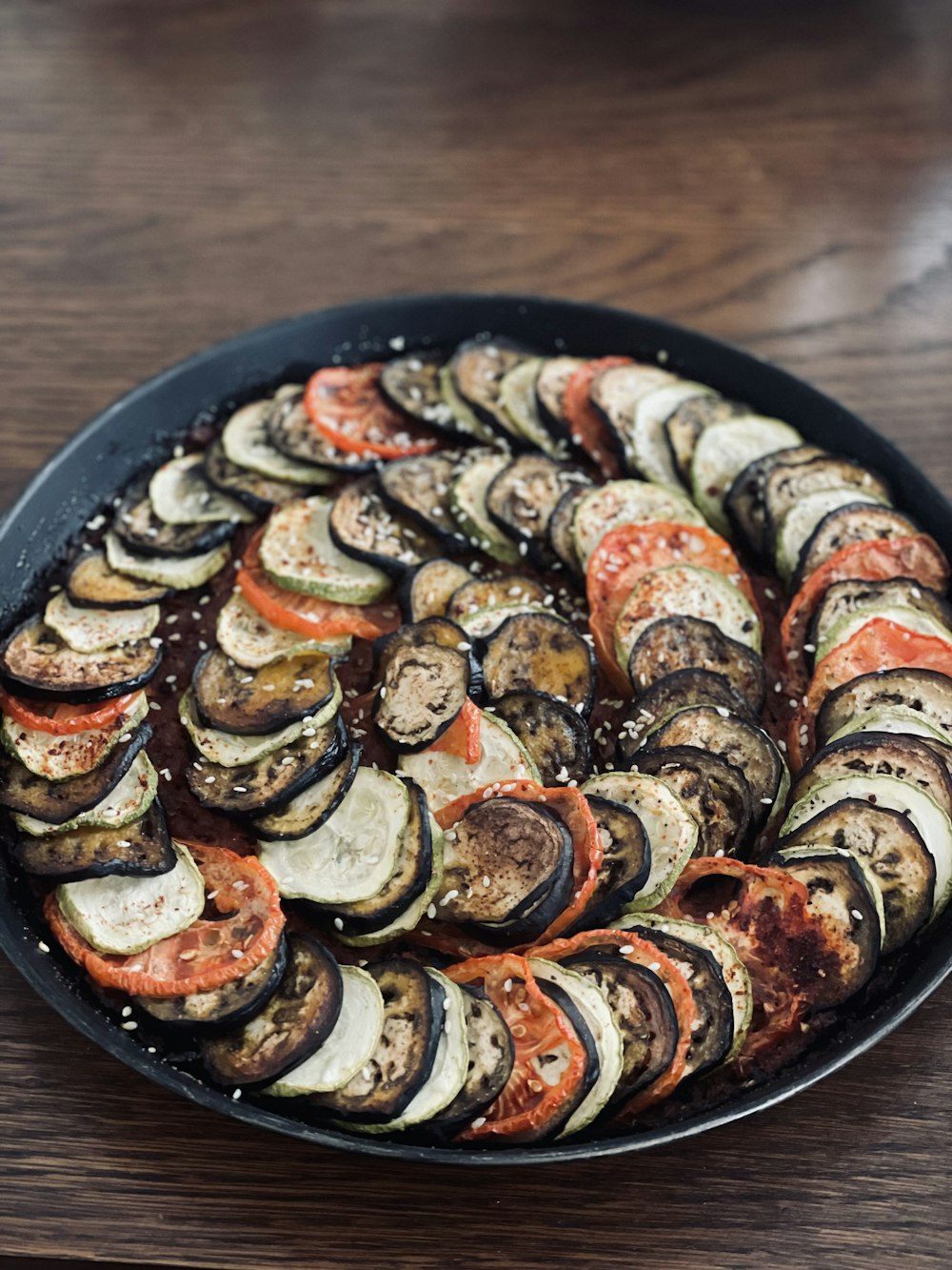 a pan filled with sliced up vegetables on top of a wooden table