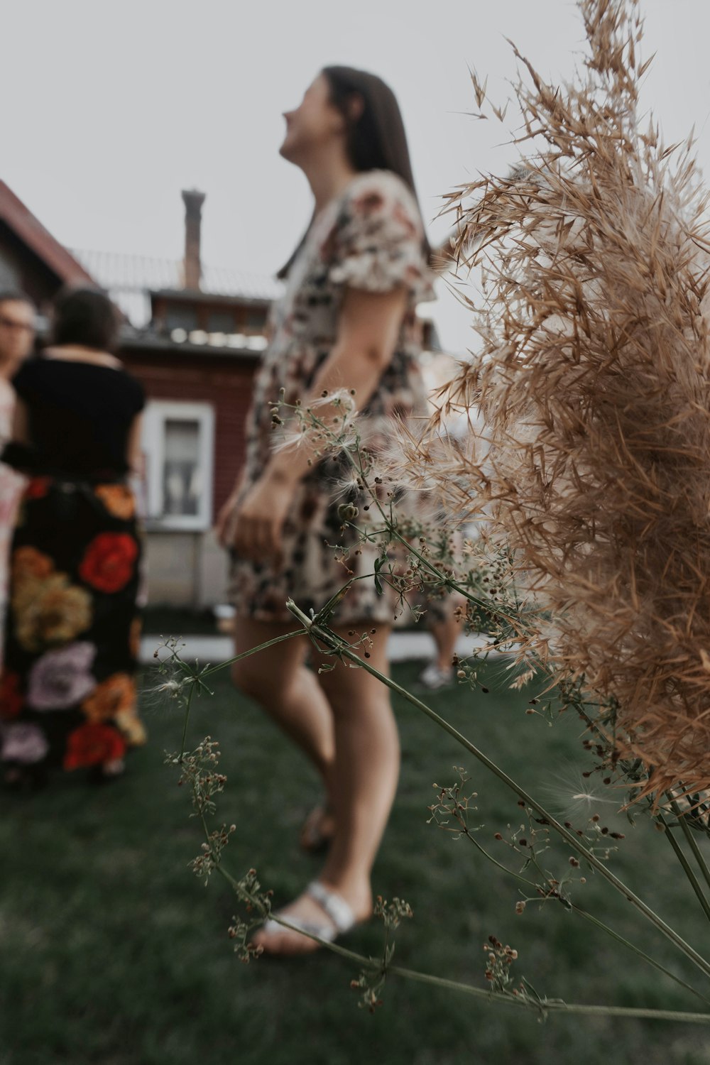a woman in a floral dress standing in the grass