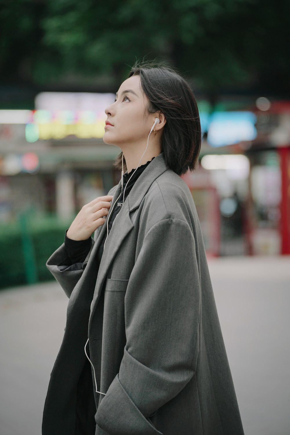 a woman in a gray coat is looking up