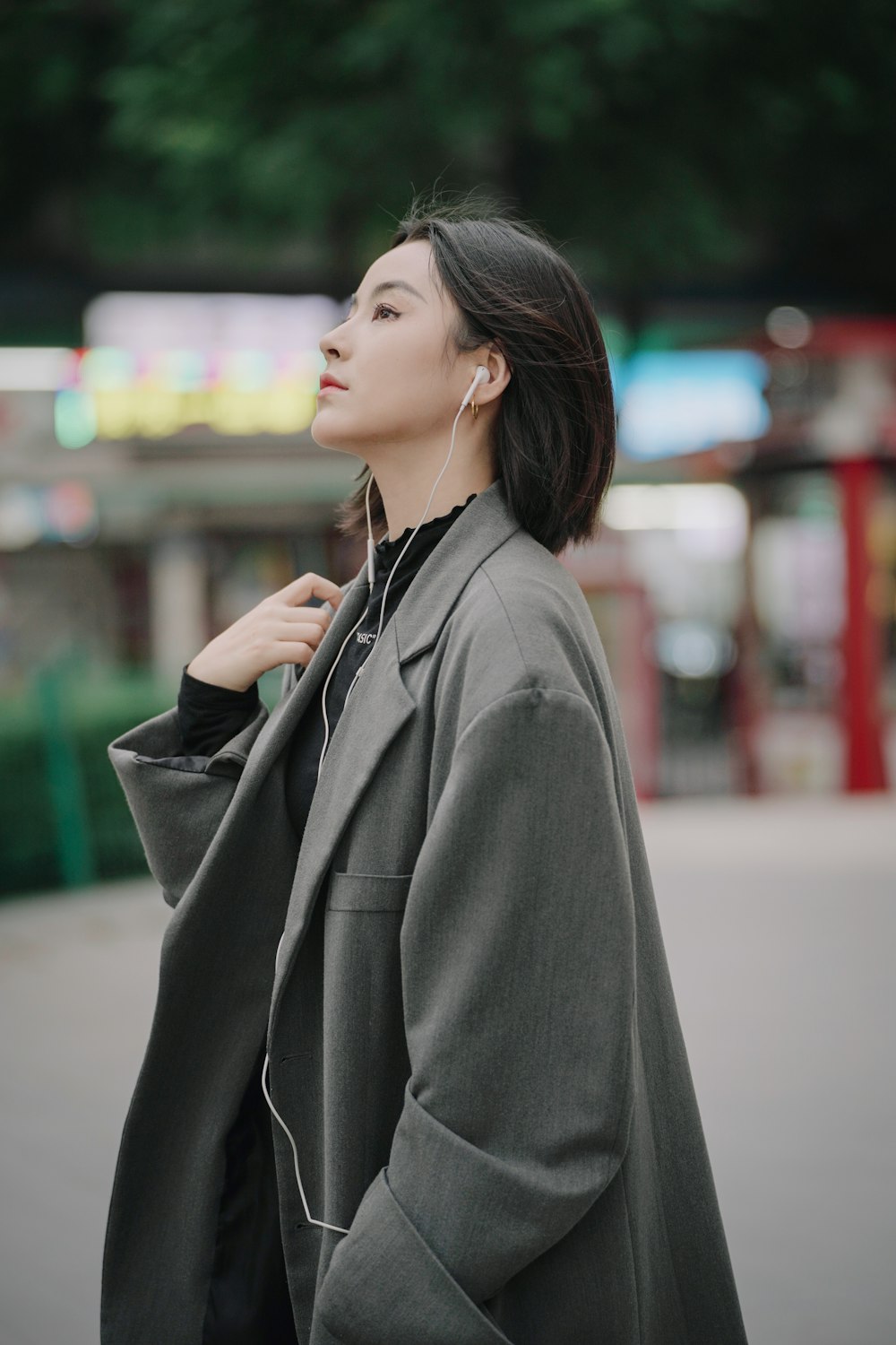 a woman wearing ear buds and a coat