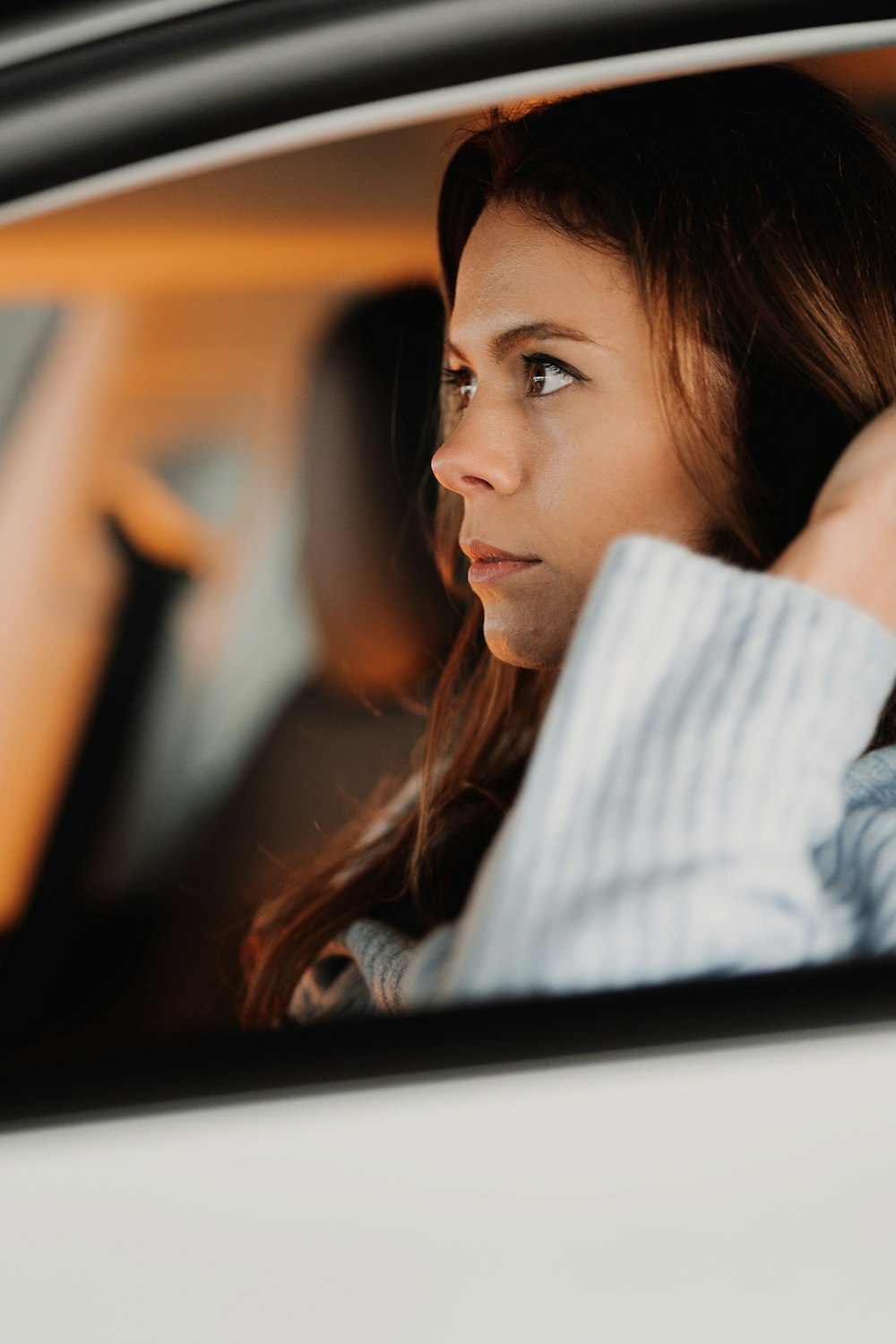 a woman sitting in a car looking out the window