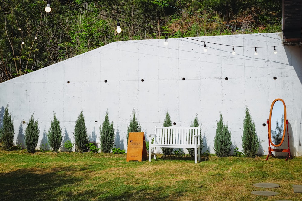 a white bench sitting in front of a white wall