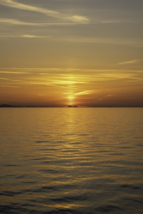 A serene image of a sunset over a tranquil sea, reflecting cool colors.