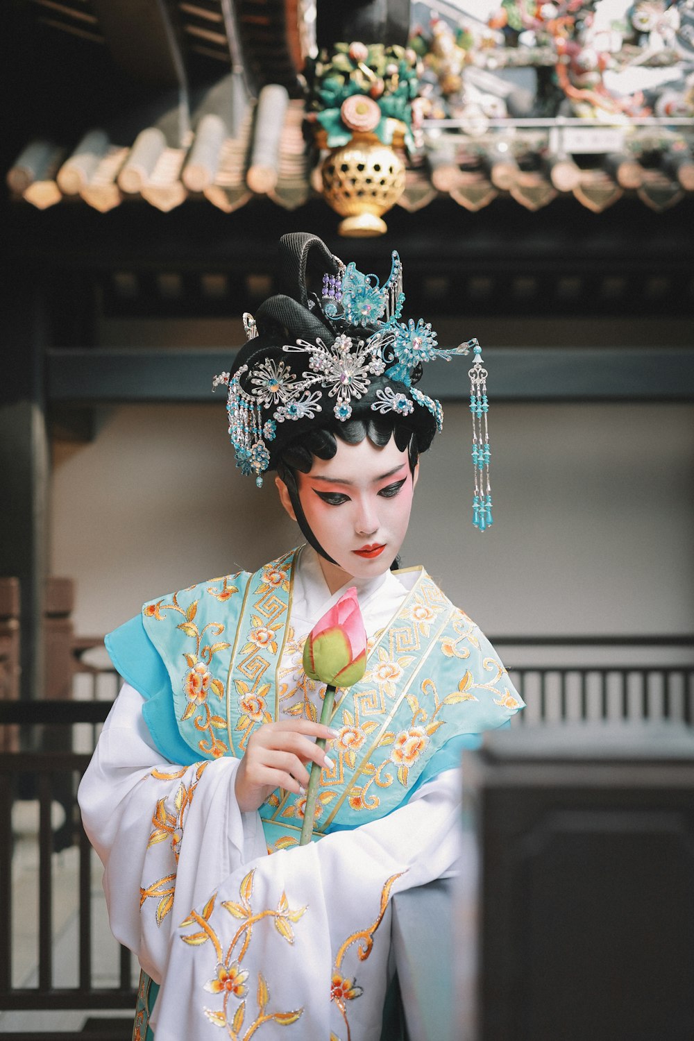 a woman in a geisha costume holding a flower