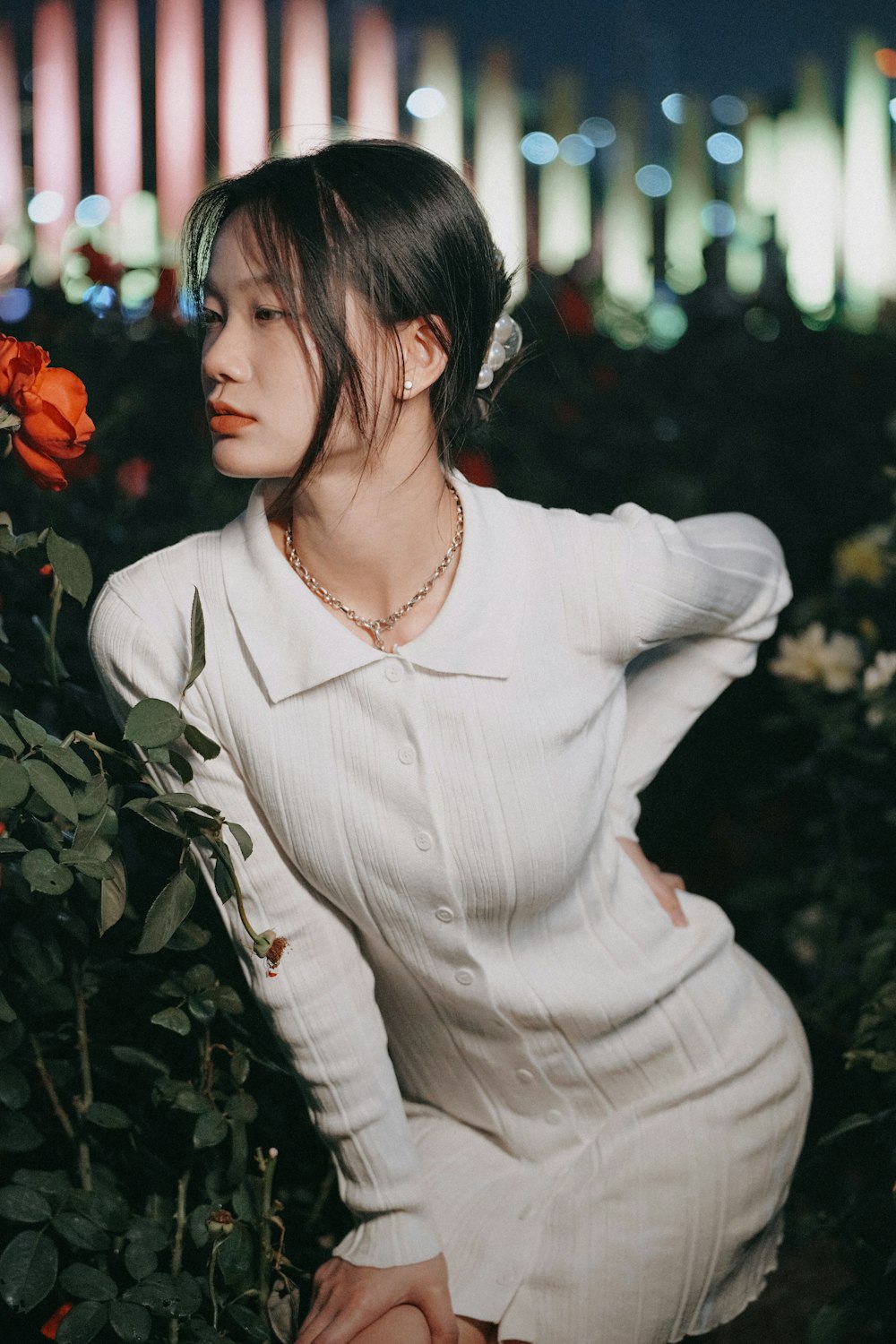 a woman in a white dress sitting in a field of flowers