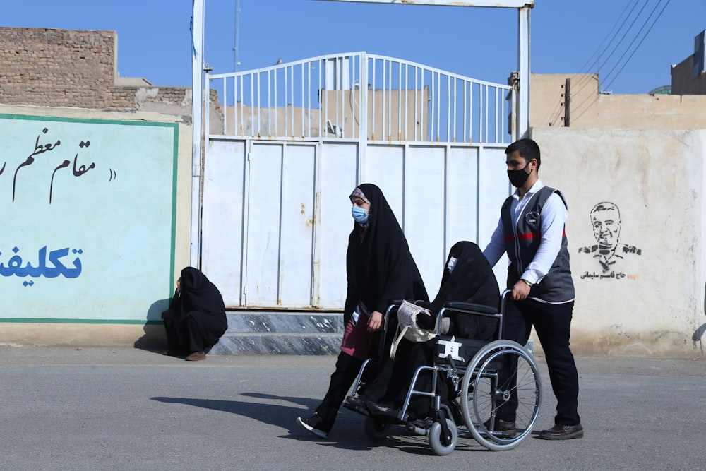 a man pushing a woman in a wheel chair