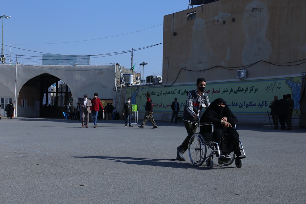 a man pushing a woman in a wheel chair