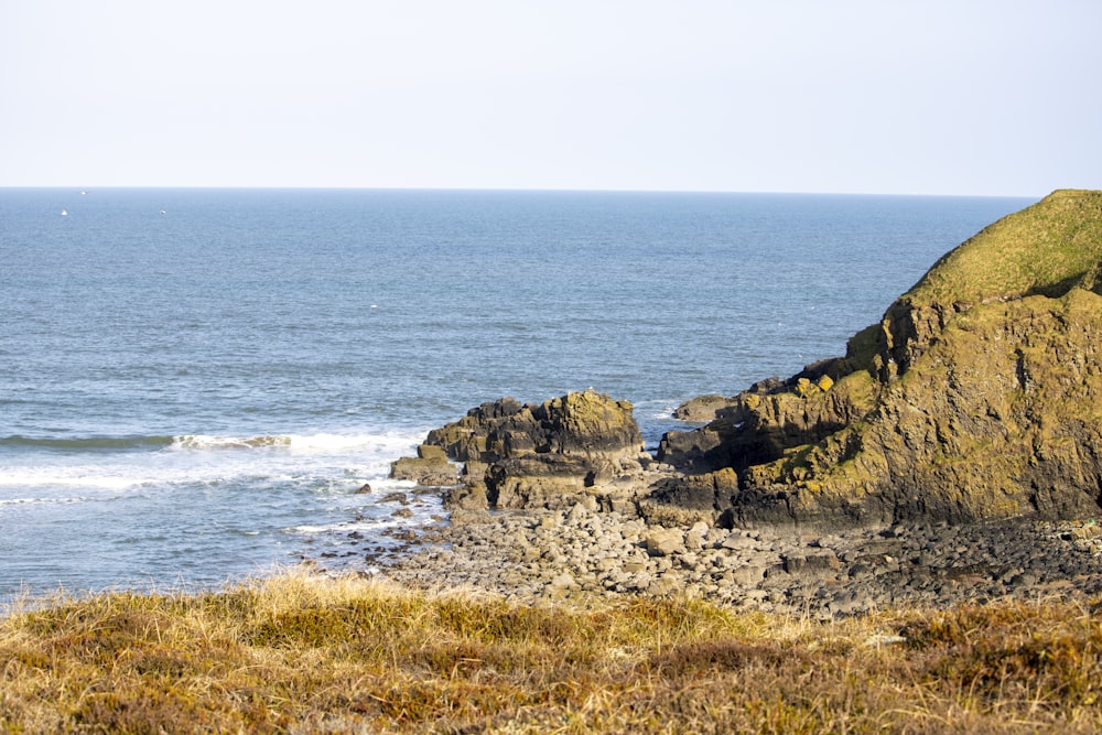 a large body of water sitting next to a rocky shore