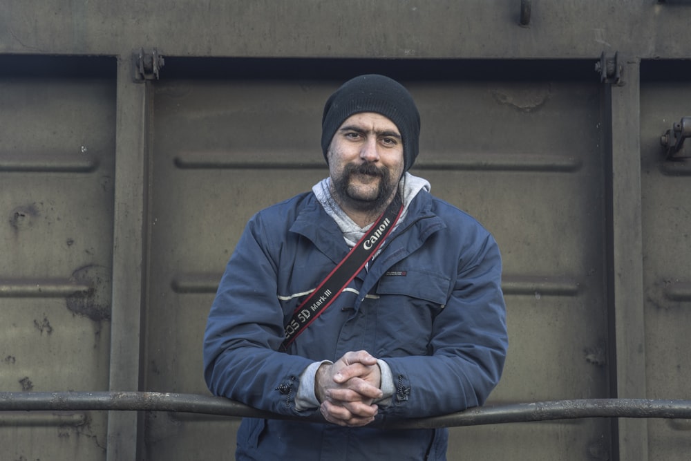 a man standing in front of a metal gate