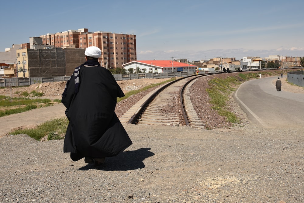 a person sitting on the ground near a train track