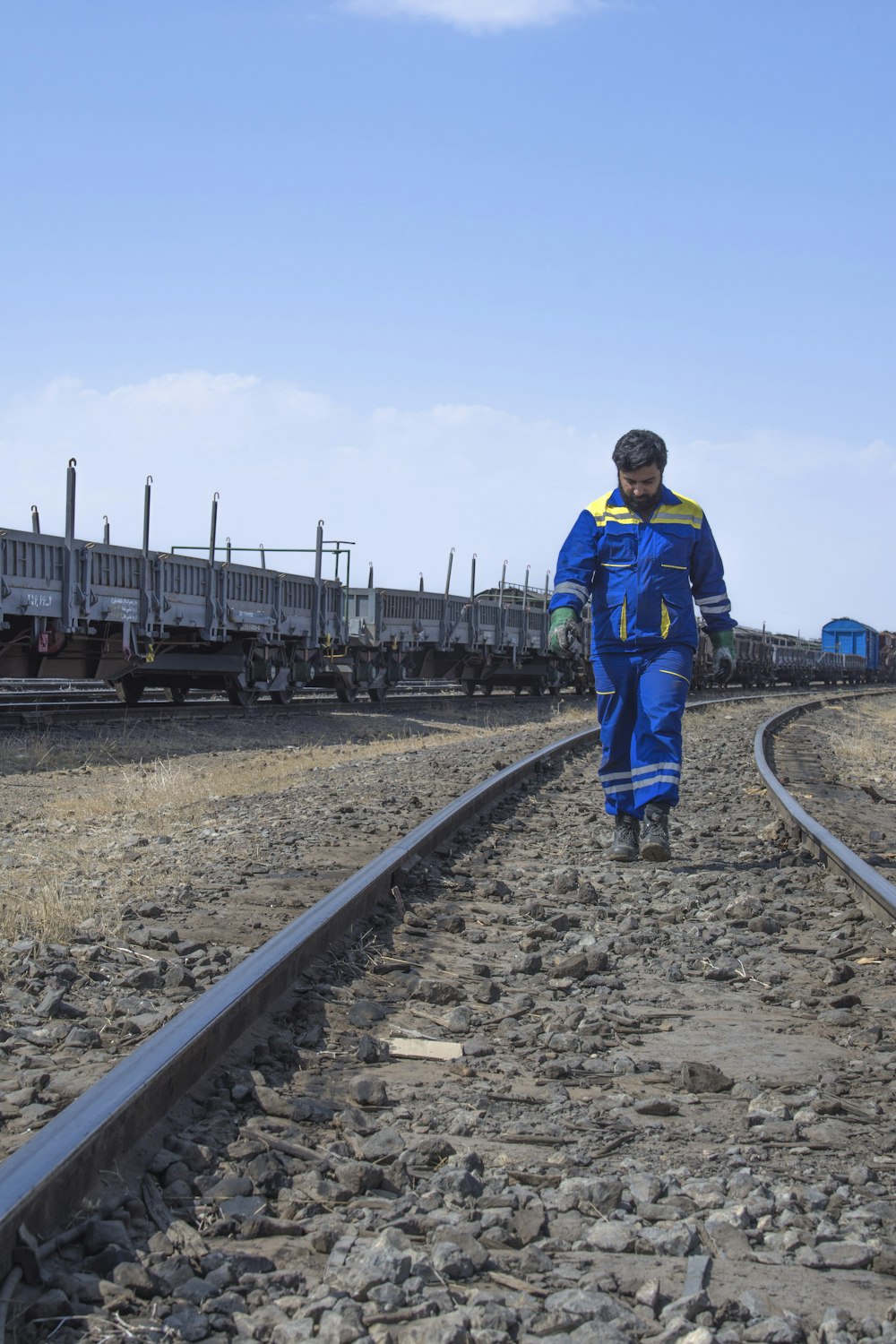 a man walking down a train track next to a train