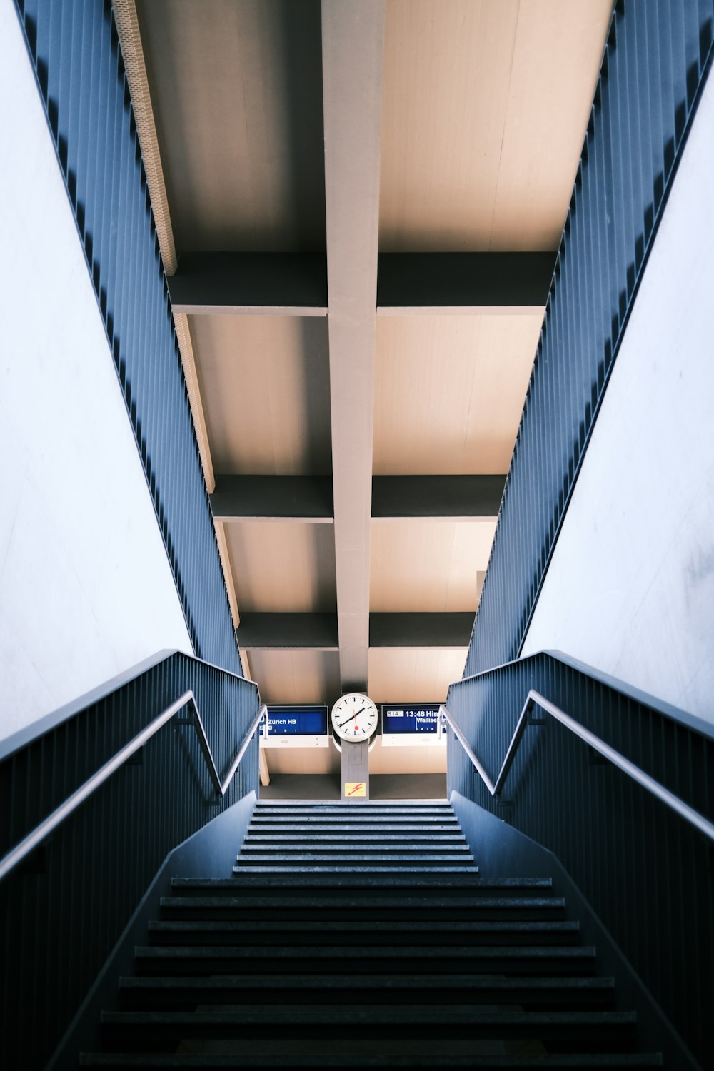 an escalator with a clock in the middle of it