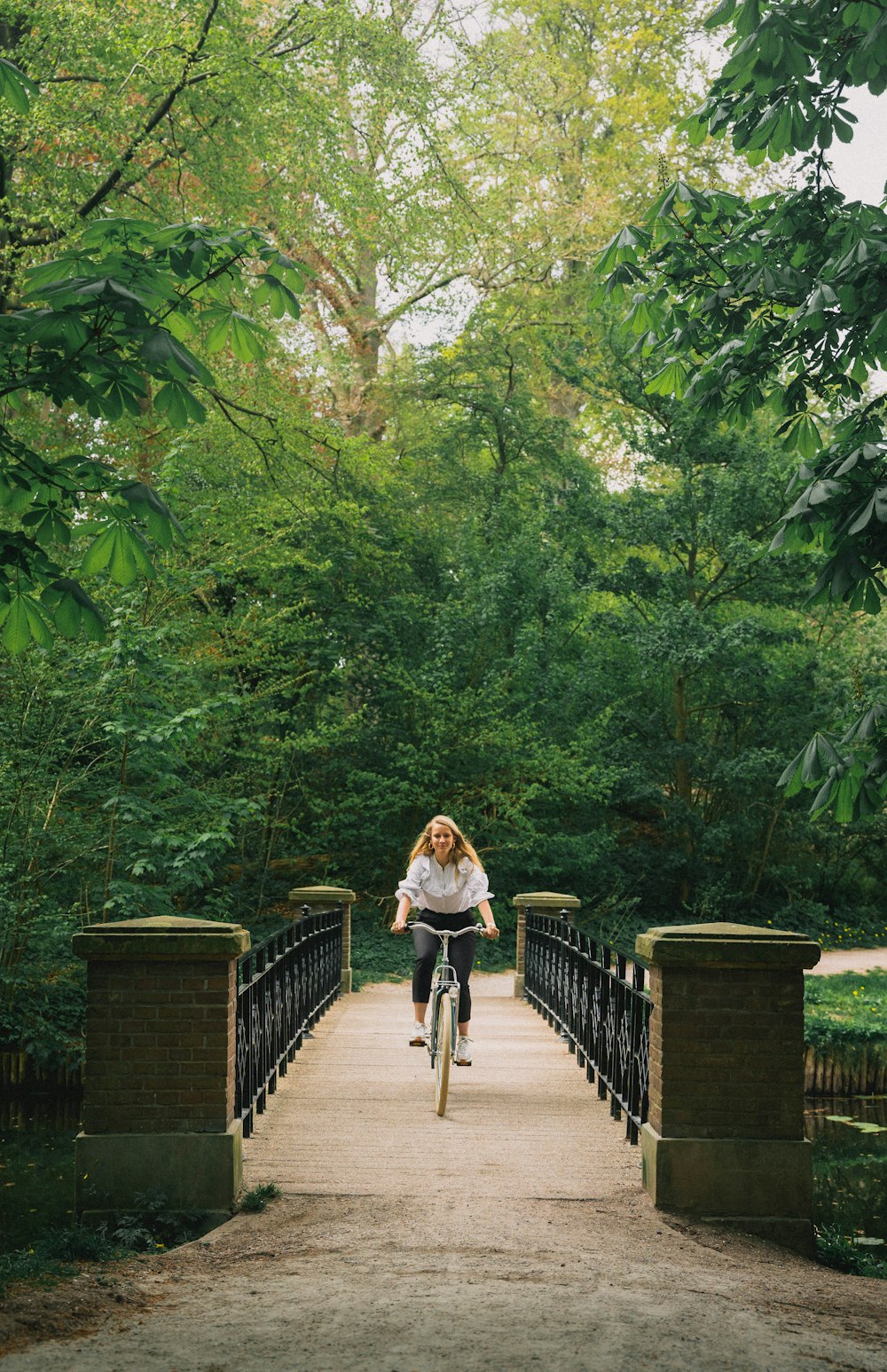 Eine Frau fährt mit dem Fahrrad über eine Brücke