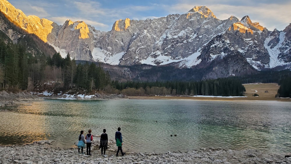 a group of people standing next to a body of water