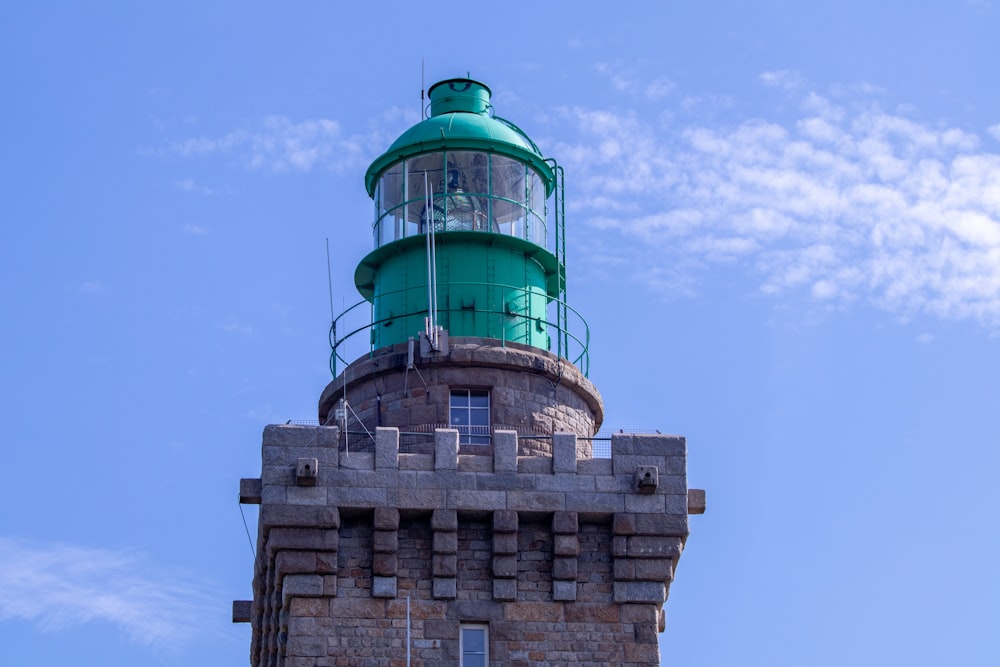 a green light house on top of a brick building