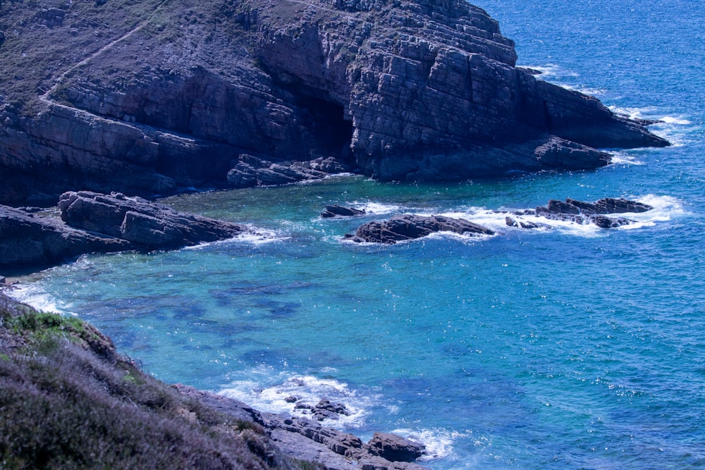 a large body of water next to a rocky shore