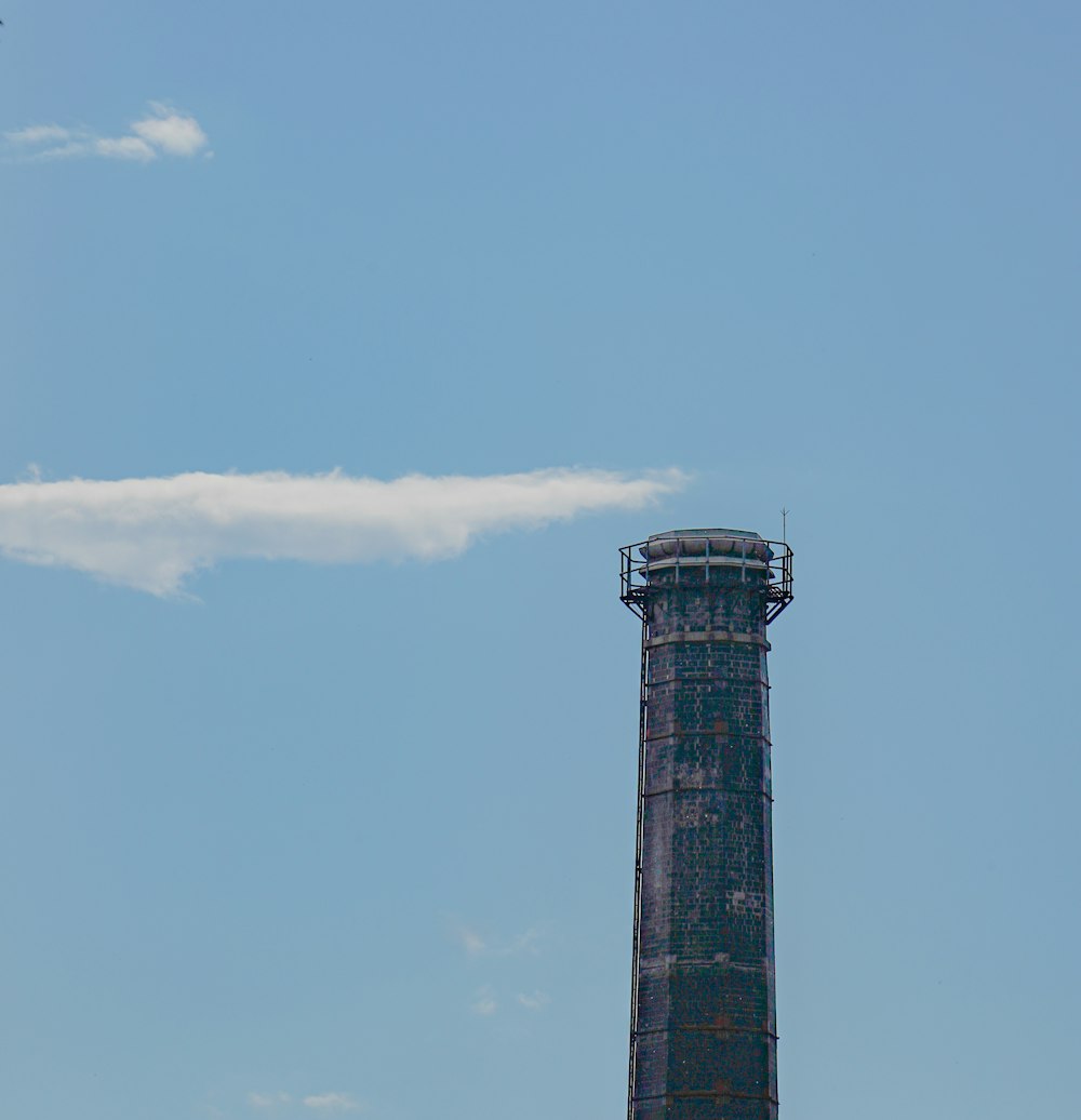 a plane flying in the sky near a tower