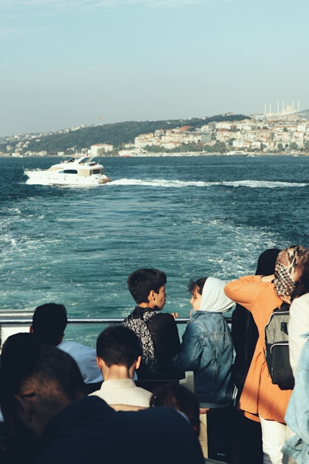 Happy friends relaxing on the deck of a medium-sized yacht, surrounded by city skyline