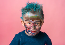 a young boy with blue hair and face paint