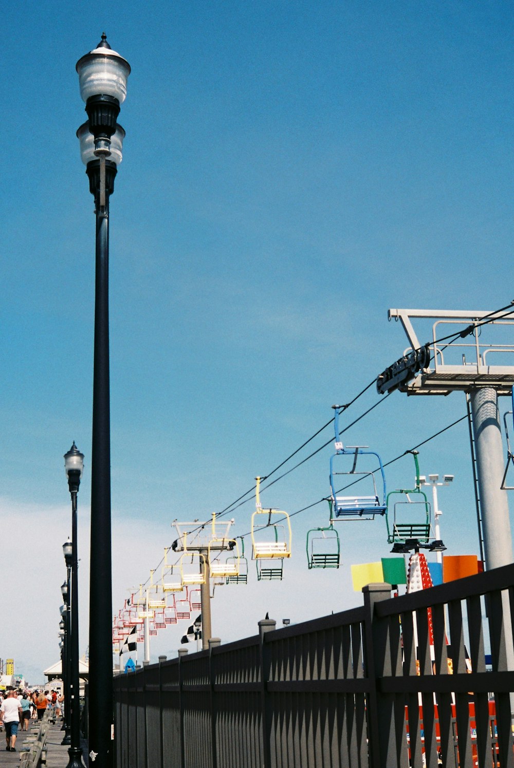 a street light sitting next to a black fence