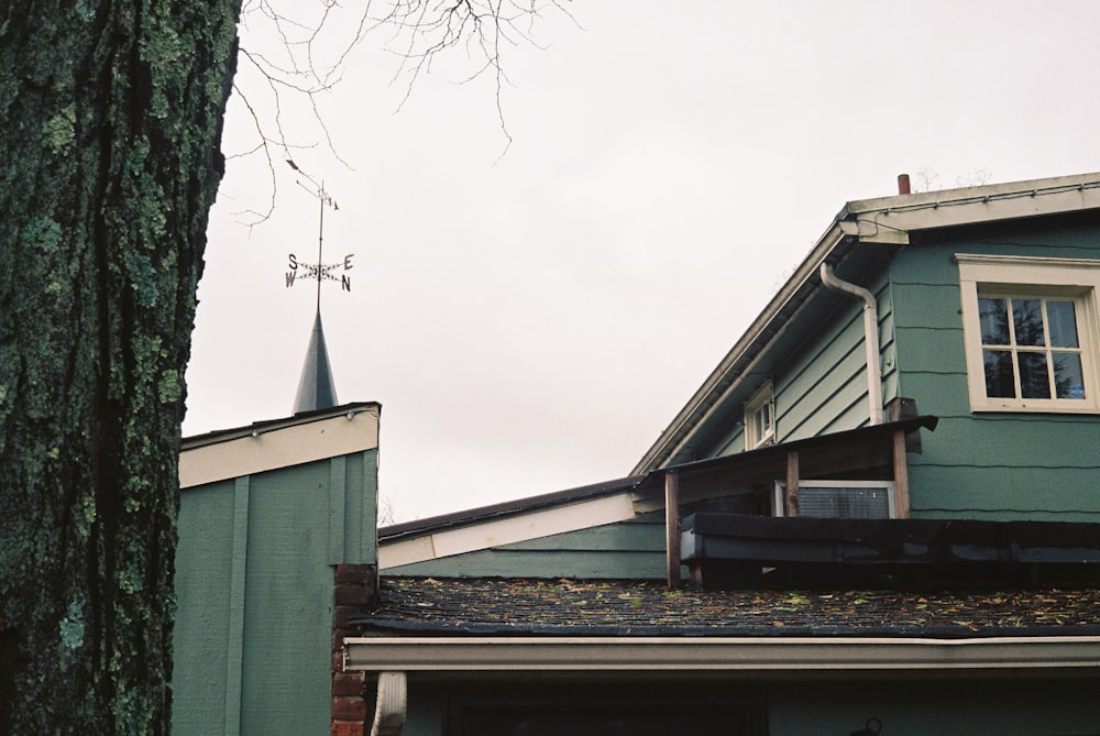 Una casa verde con un campanario y una torre del reloj