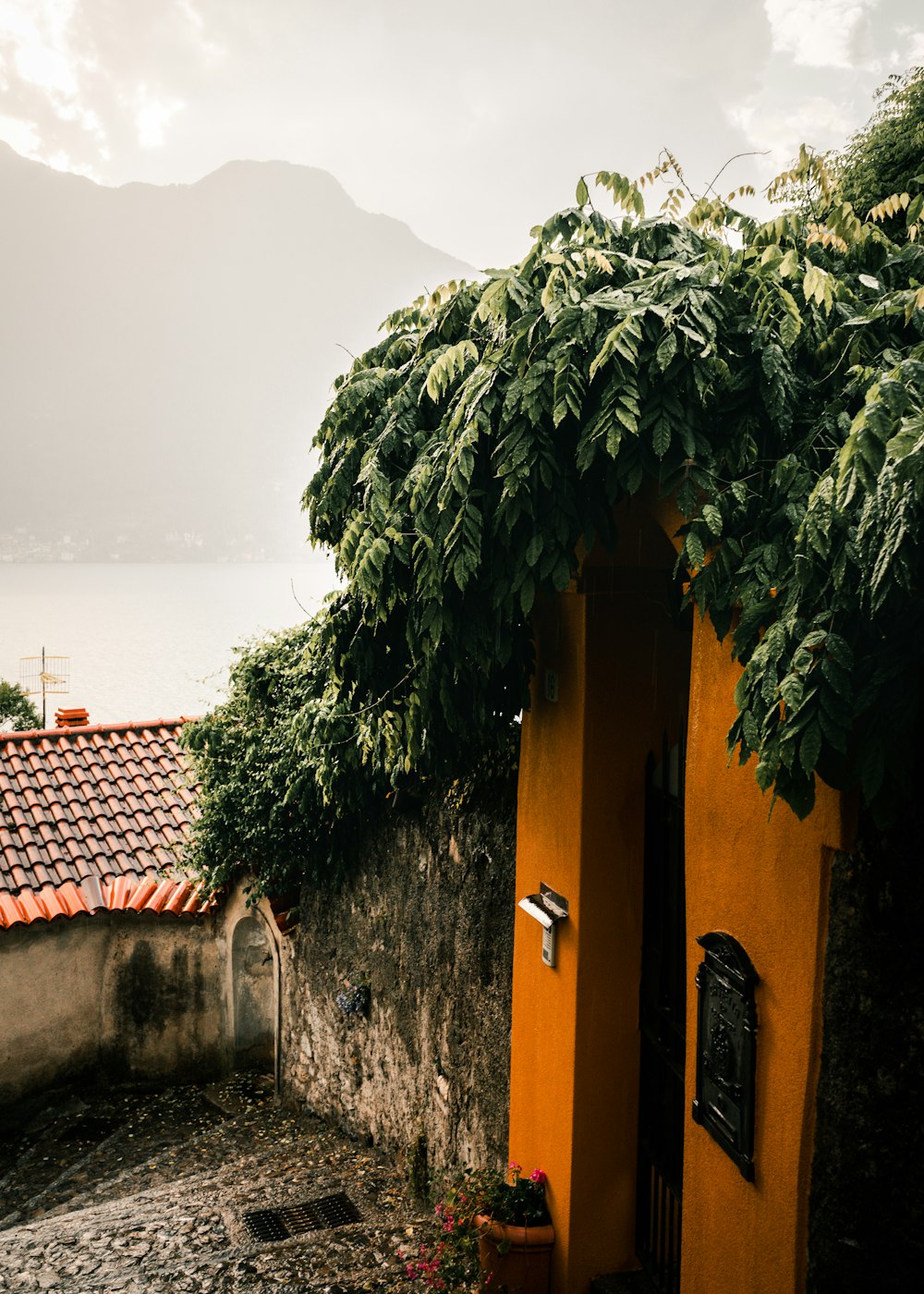 a yellow building with a red roof next to a body of water