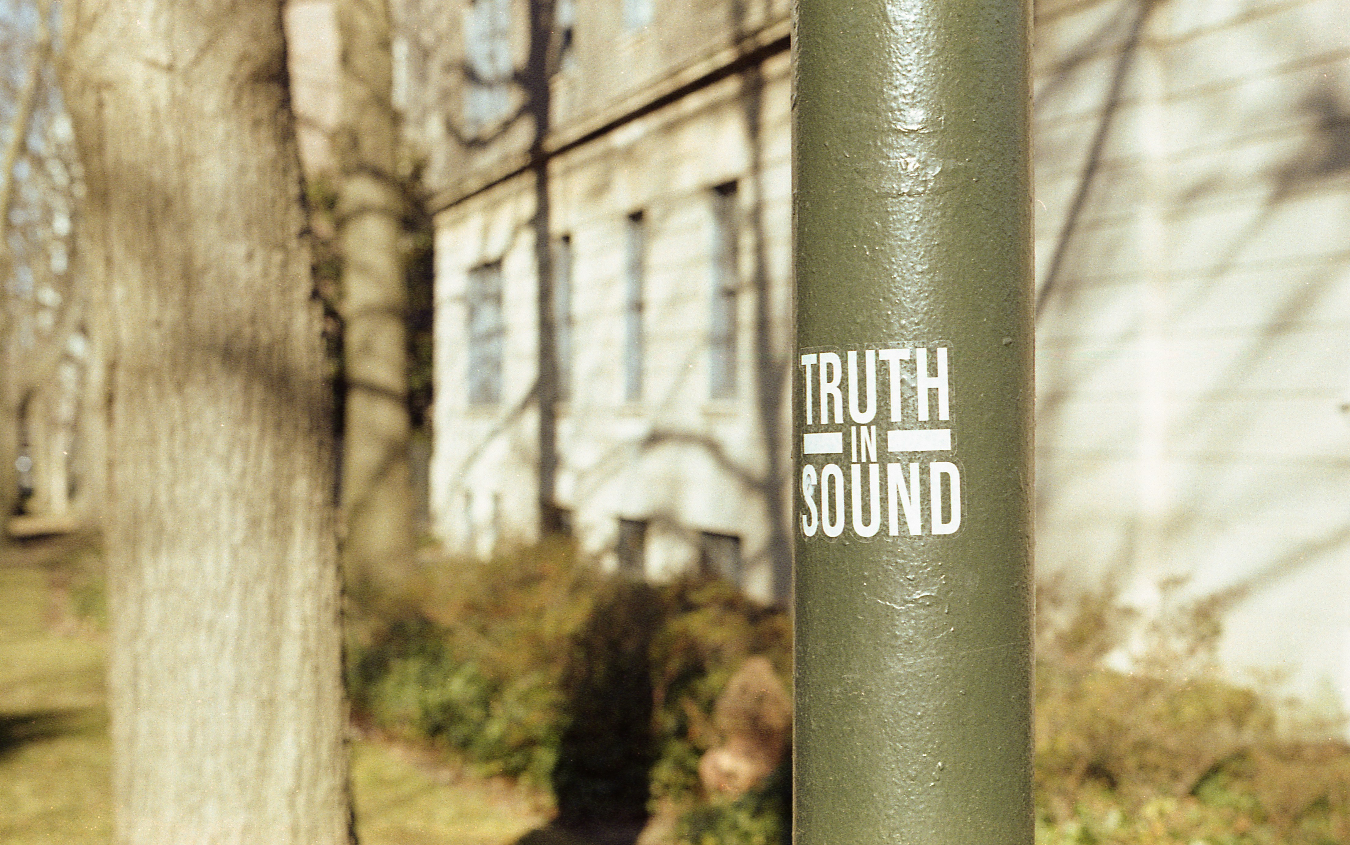 a green pole with a sticker on it in front of a building (Photo by E. Vitka on Unsplash)