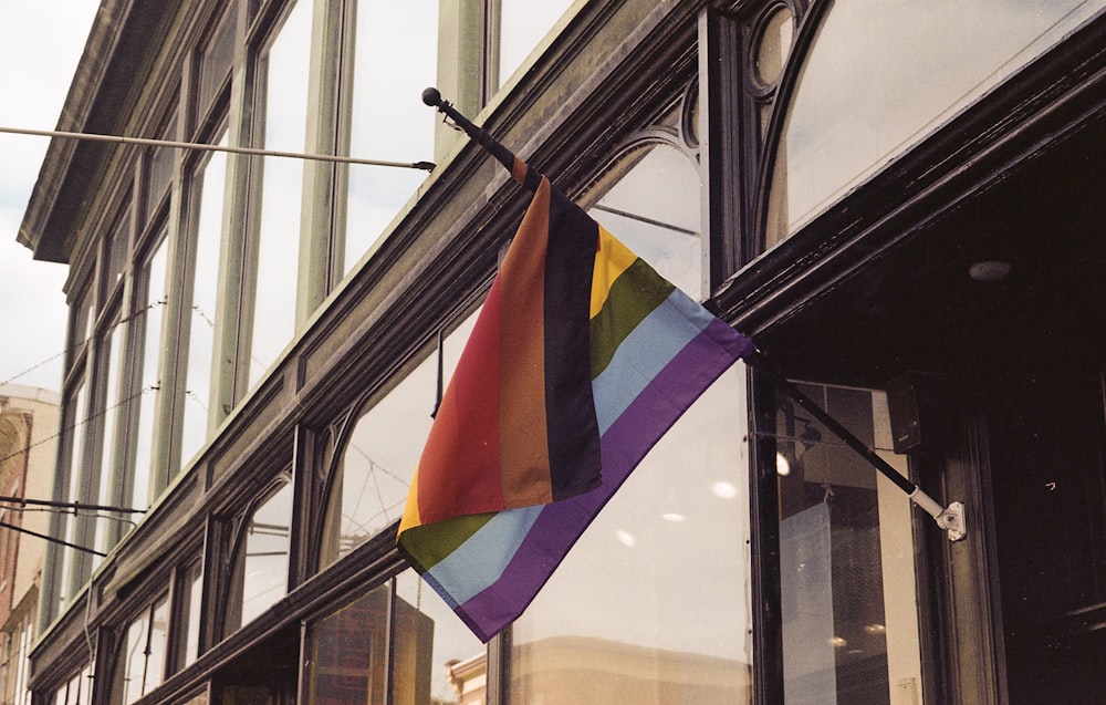 a rainbow flag hanging outside of a building