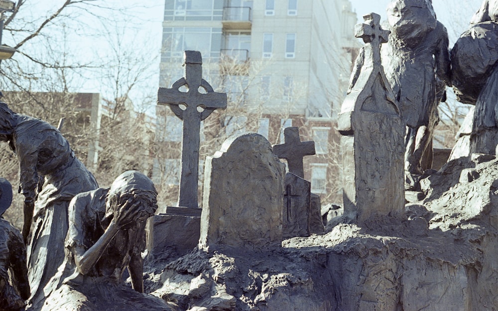 un cimitero con statue di persone e croci