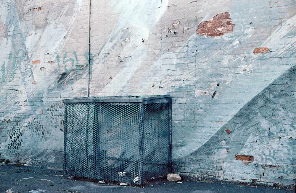 a trash can sitting on the side of a building