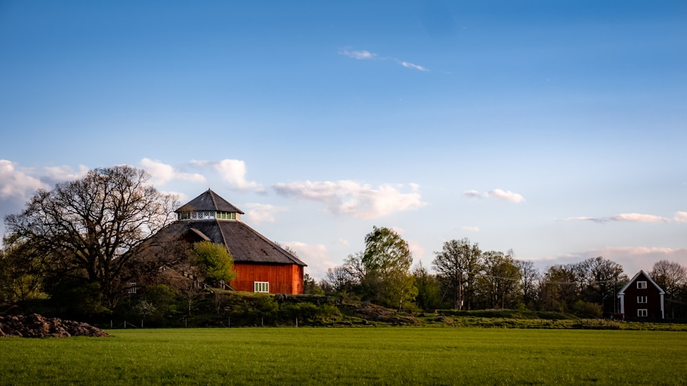 a barn with a thatched roof in a field