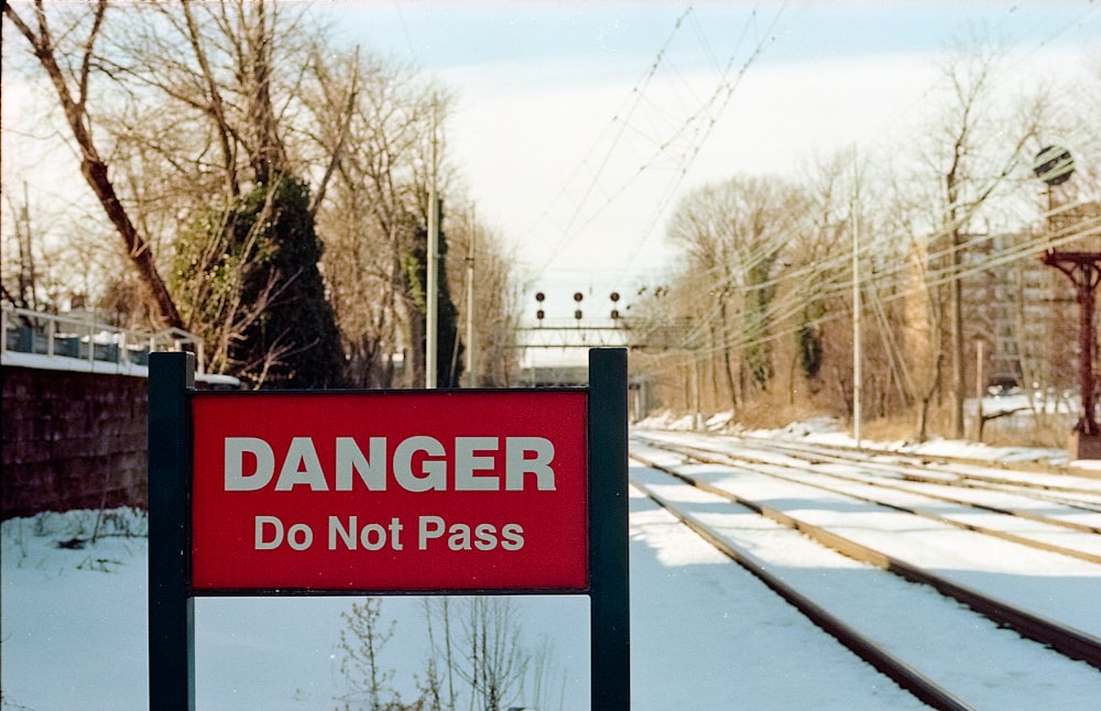 a red sign sitting on the side of a train track
